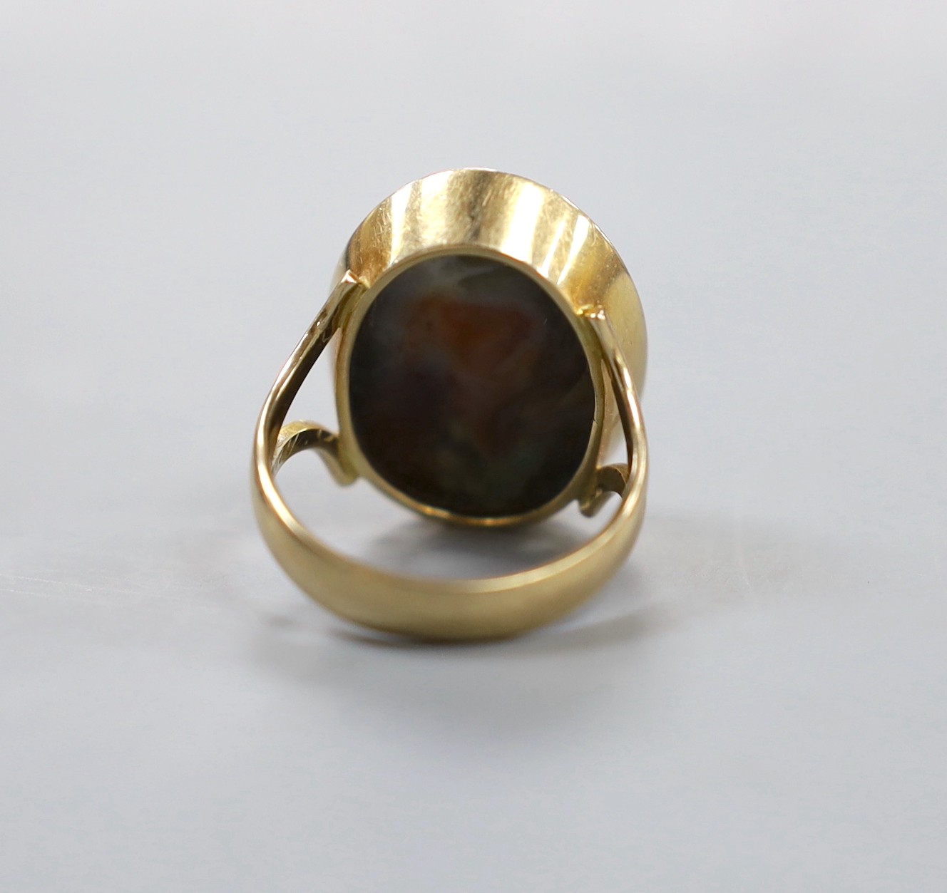 A yellow metal and cabochon polychrome agate? set oval ring, with engraved inscription to the shank, size O, gross weight 10.6 grams.